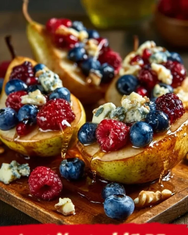Baked pears with berries, honey, walnuts, and blue cheese on a serving plate